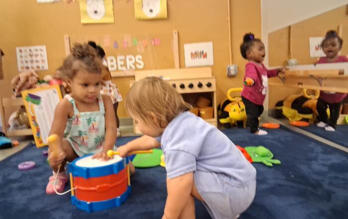 Group play, number boards, and toy instruments during circle time at Kid-Tastic